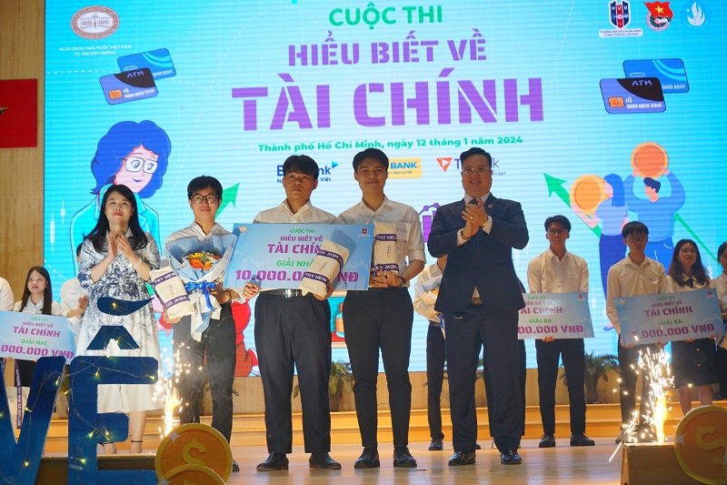 Bà Kim Lan Anh, Phó Vụ trưởng Vụ Truyền thông NHNN (ngoài cùng bìa trái) và PGS.TS Nguyễn Đức Trung - Hiệu trưởng trường ĐH Ngân hàng TP HCM trao giải thưởng cho các đội thi 